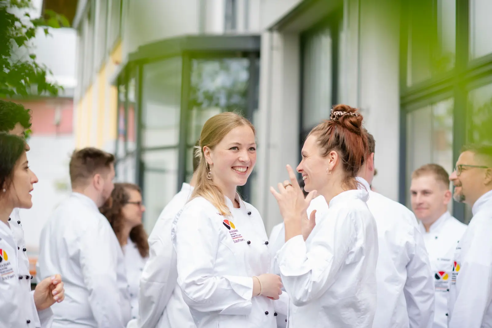 Meisterschülerinnen und Meisterschüler im Gespräch vor dem Gebäude der Akademie